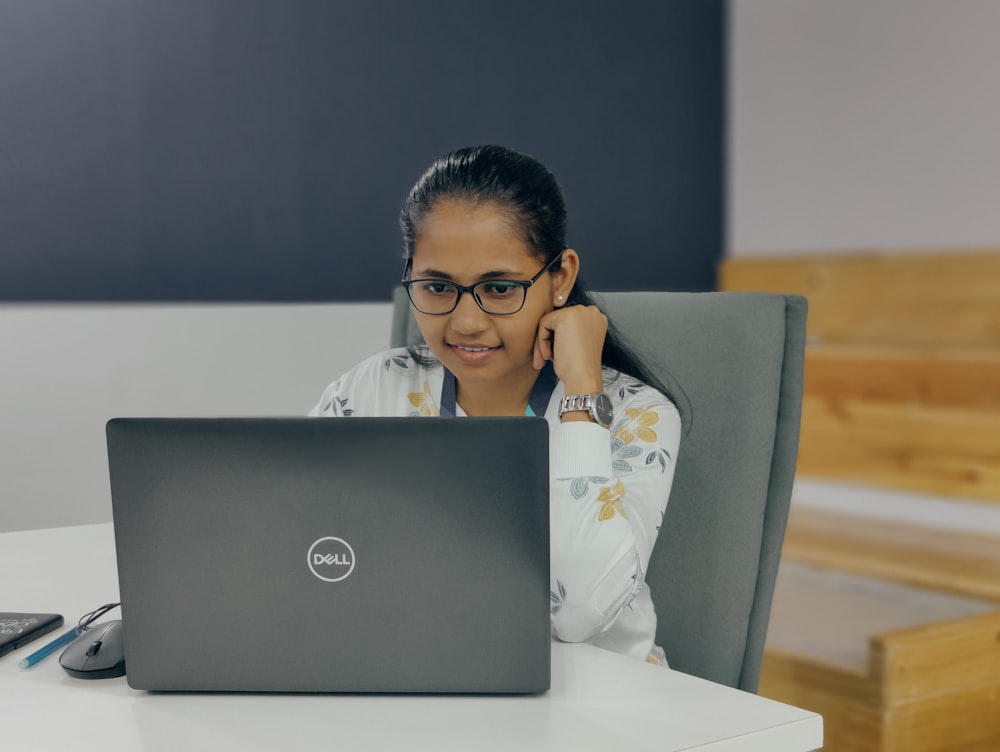 a woman sitting in front of a laptop computer