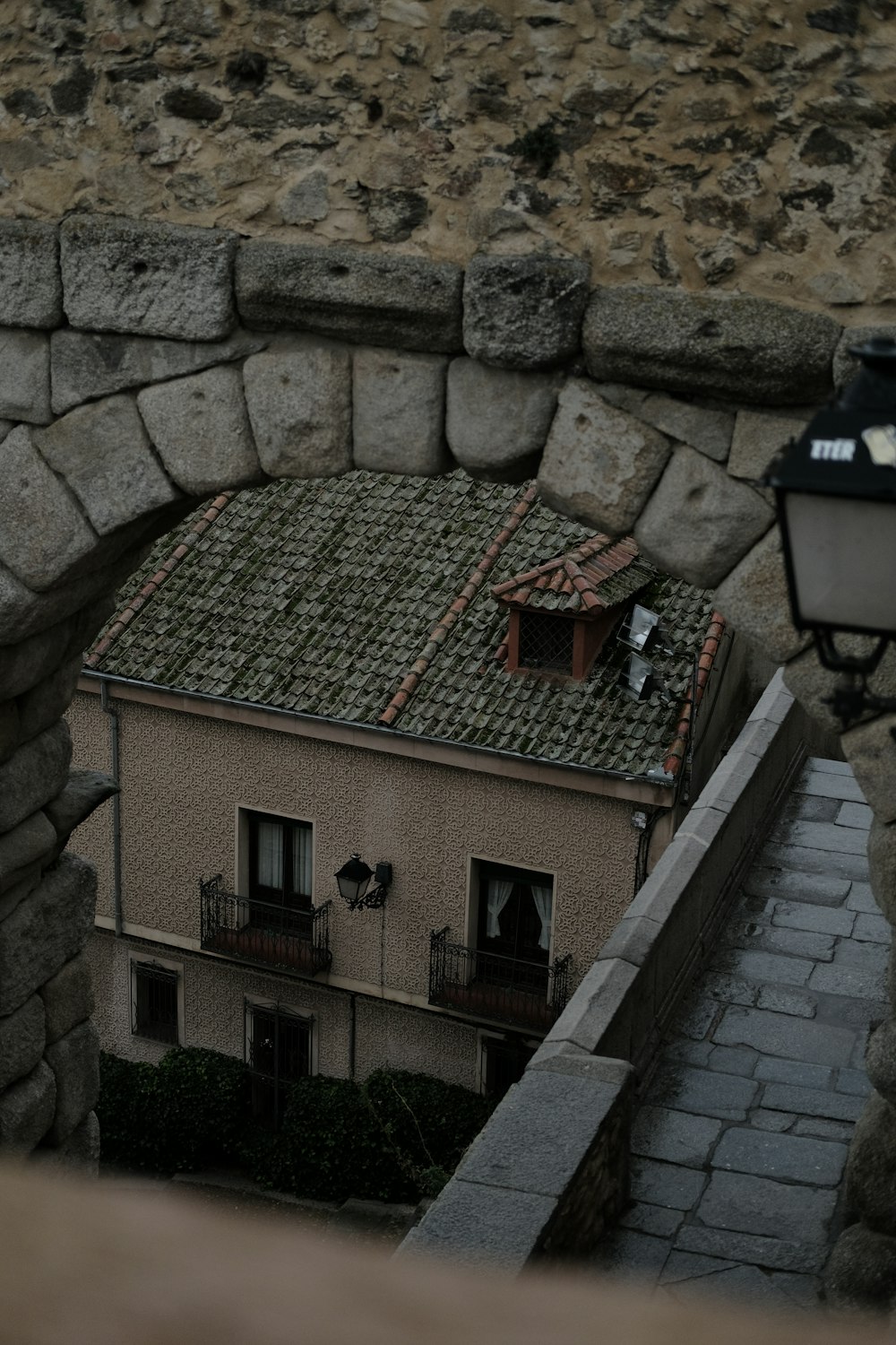 a view of a building through a stone wall