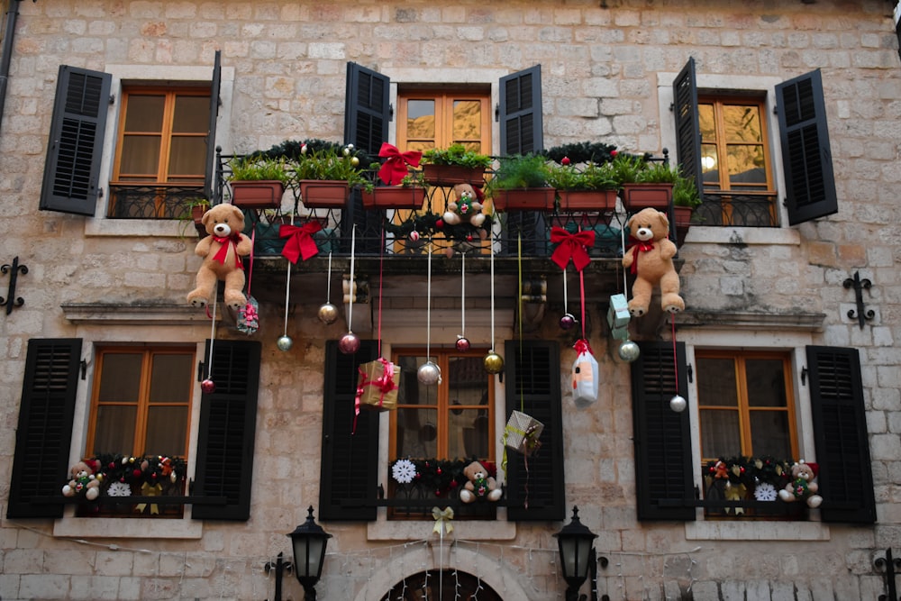 two teddy bears are hanging from the windows of a building