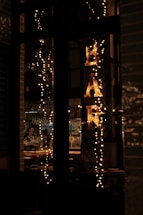 A cozy mobile bar setup at dusk with string lights and a bartender serving cocktails.