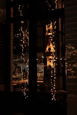 A cozy mobile bar setup at dusk with string lights and a bartender serving cocktails.