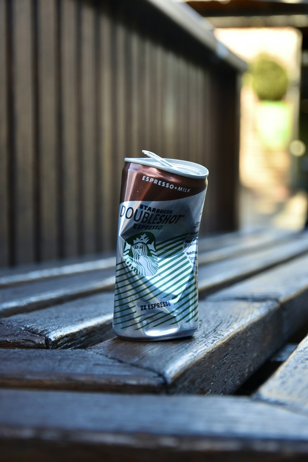 a can of soda sitting on a wooden bench