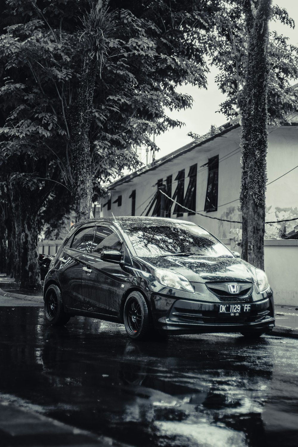 a black and white photo of a car parked on the side of the road