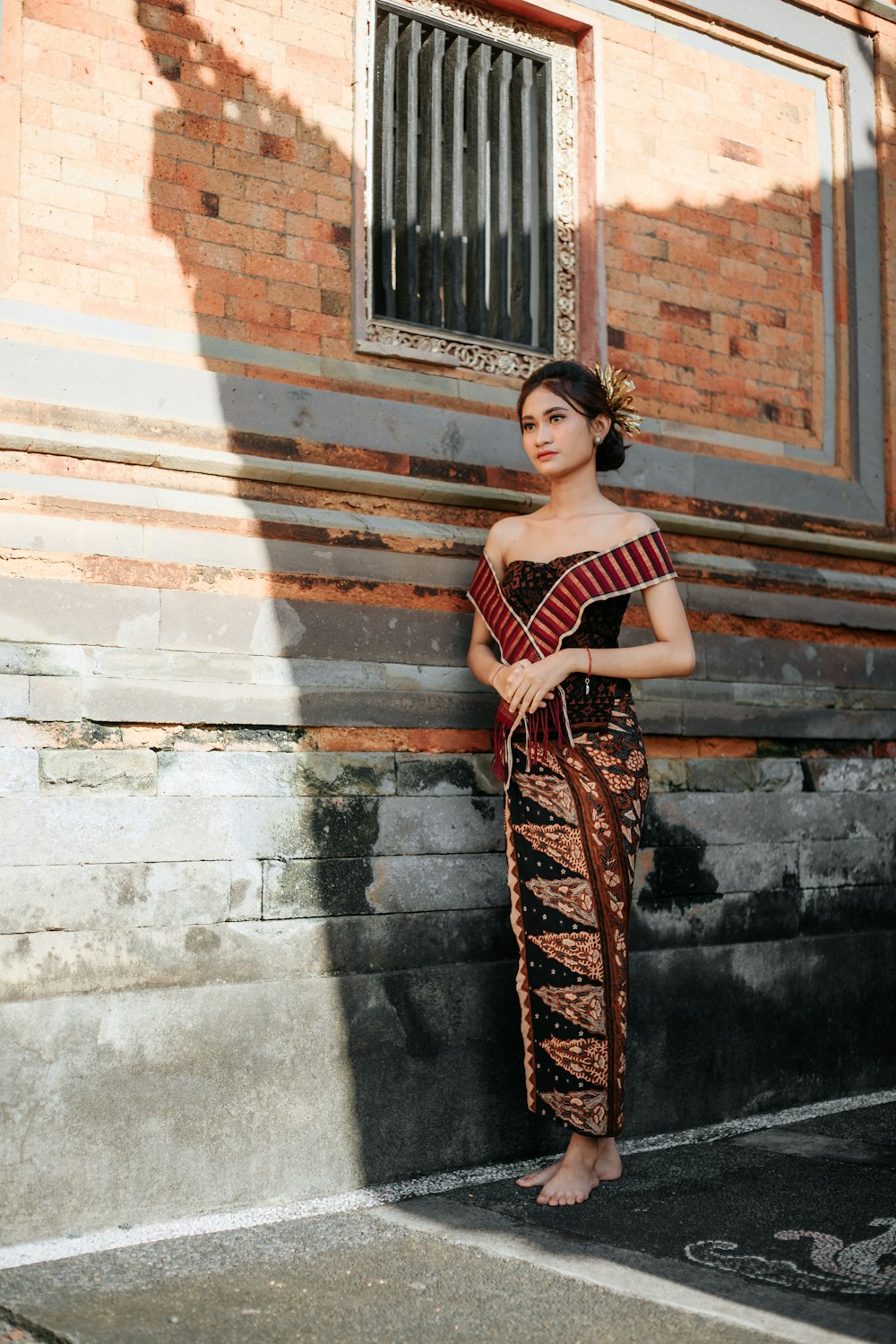 a woman standing in front of a brick building