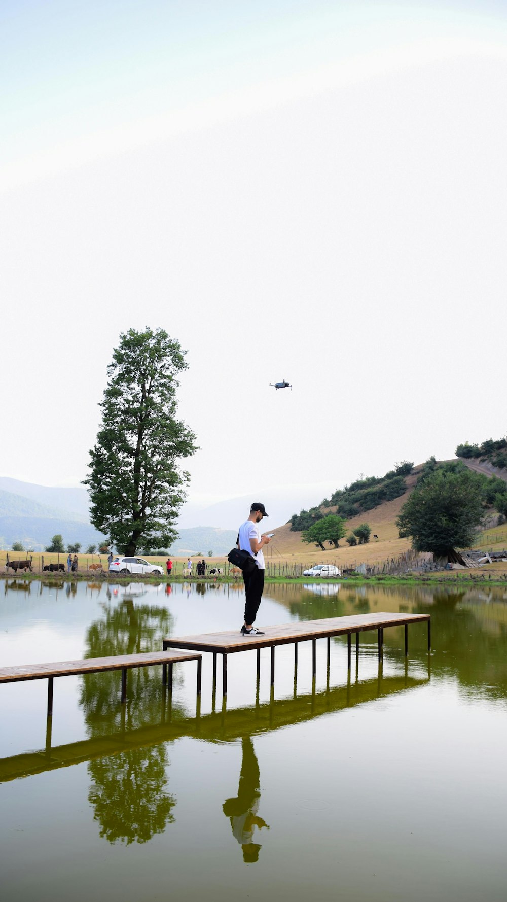 a man standing on a wooden dock over a lake