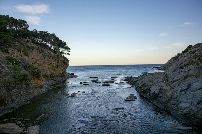Rocky cove with turquoise Mediterranean water on the Costa Brava Spain coastline near Cadaques at sunset
