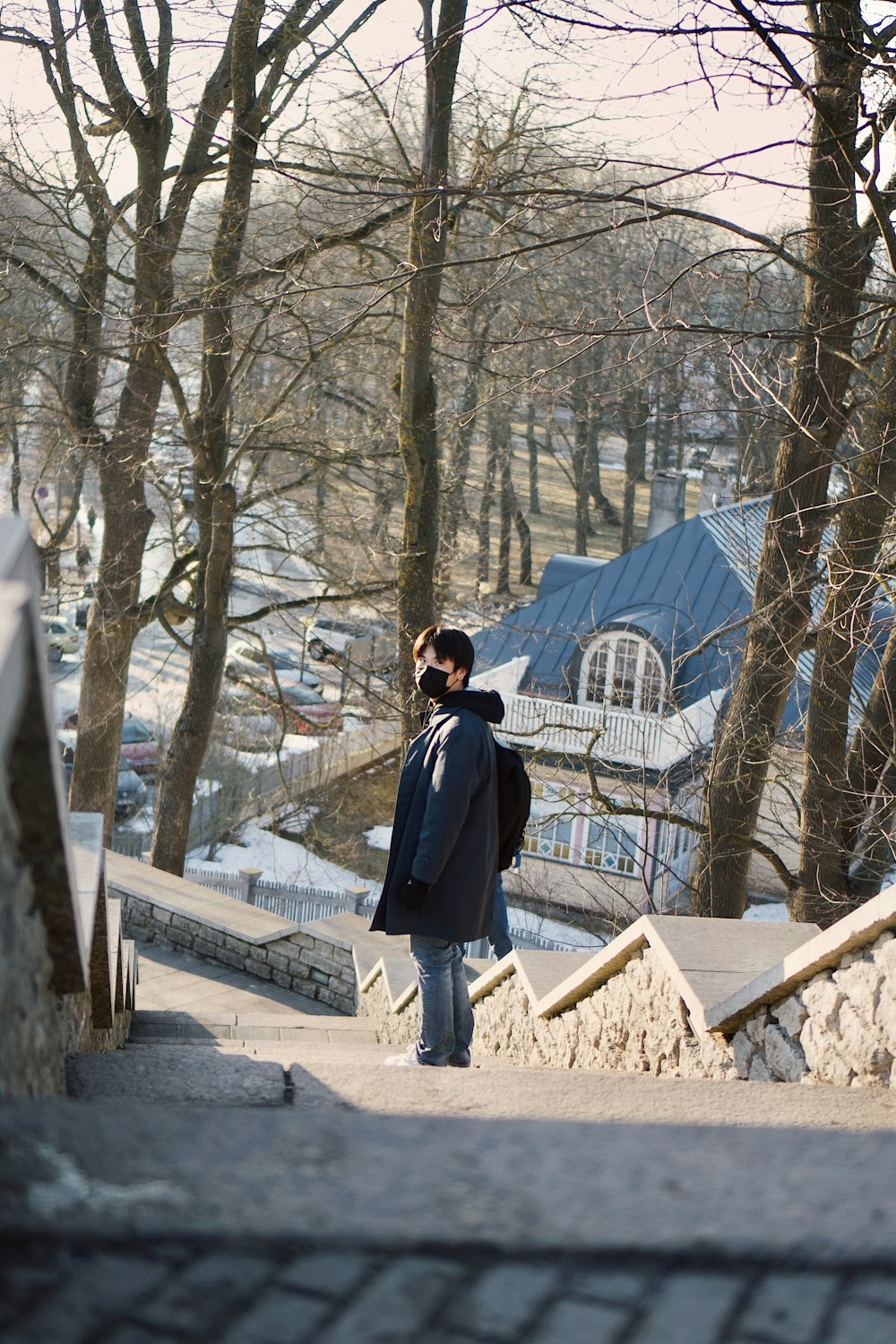 a man walking down a sidewalk next to trees