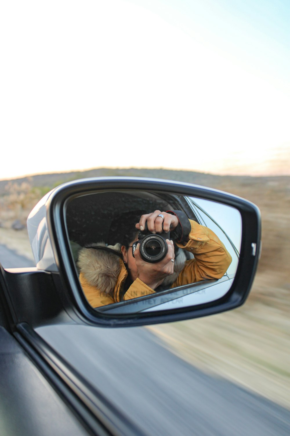 a man taking a picture of himself in a rear view mirror