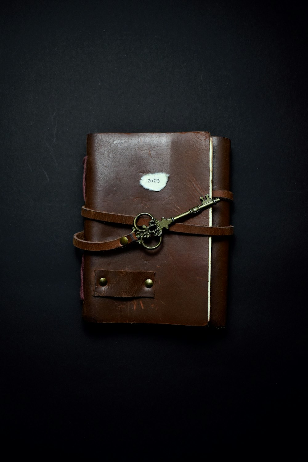 a brown leather journal with a key on it