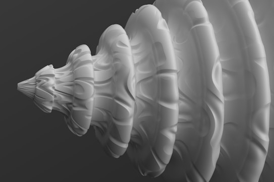 A 3D-rendered spiral structure with intricate patterns and smooth contours, resembling a shell or abstract vortex. The surface has light and shadow play, giving it a textured appearance. The background is a gradient of dark gray, enhancing the focus on the spiral.