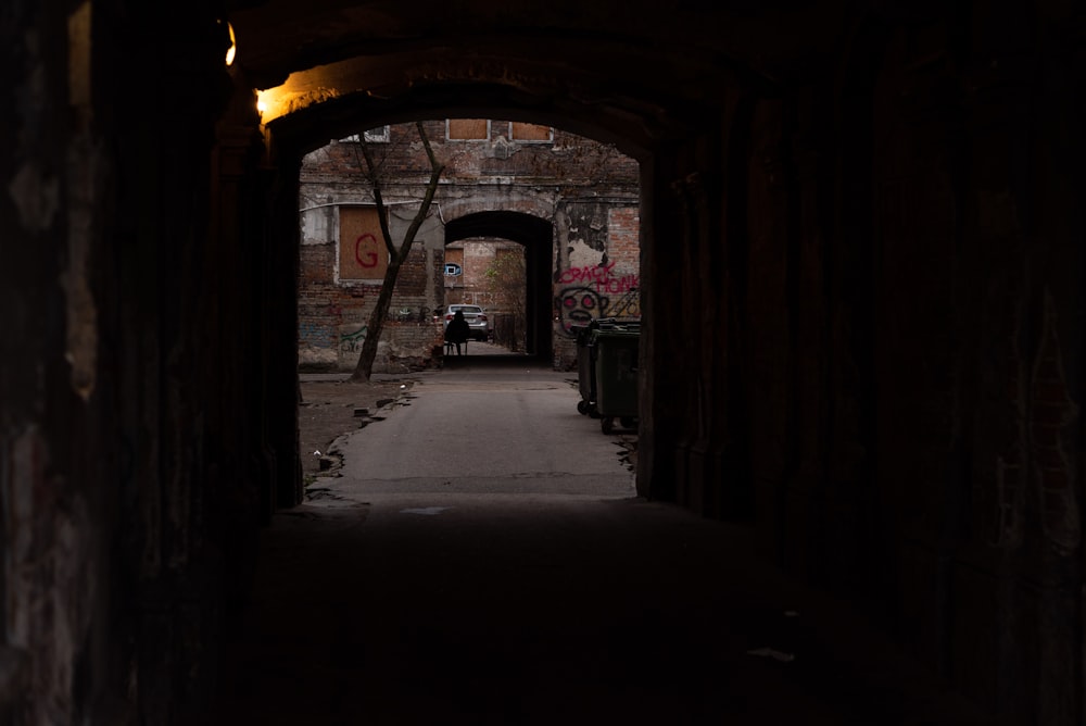 Ein dunkler Tunnel mit einer Person, die auf einer Bank sitzt