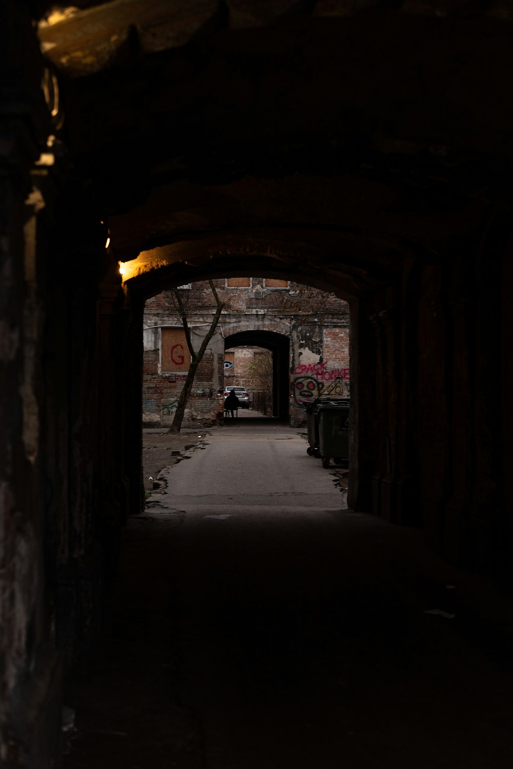 a dark tunnel with a person sitting on a bench