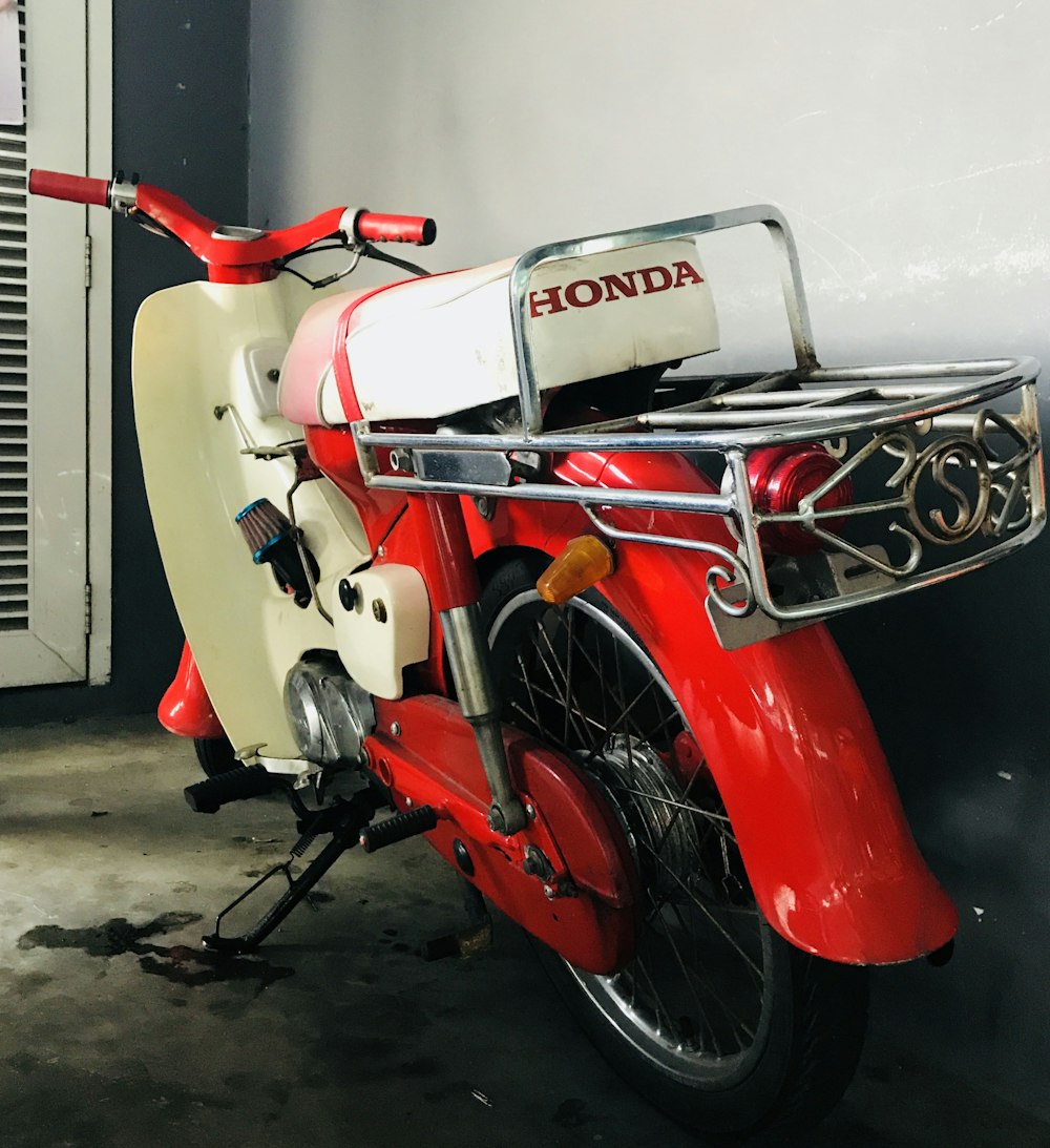 a red and white motorcycle parked in a garage