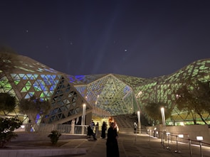 a group of people standing outside of a building at night
