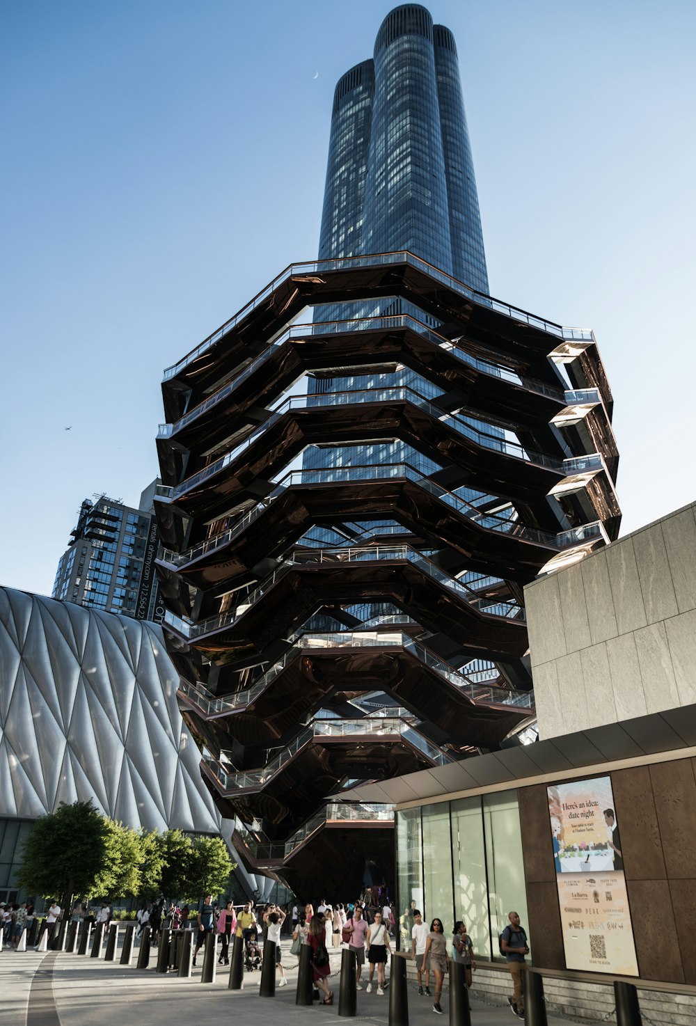 Un edificio muy alto con un montón de gente caminando a su alrededor