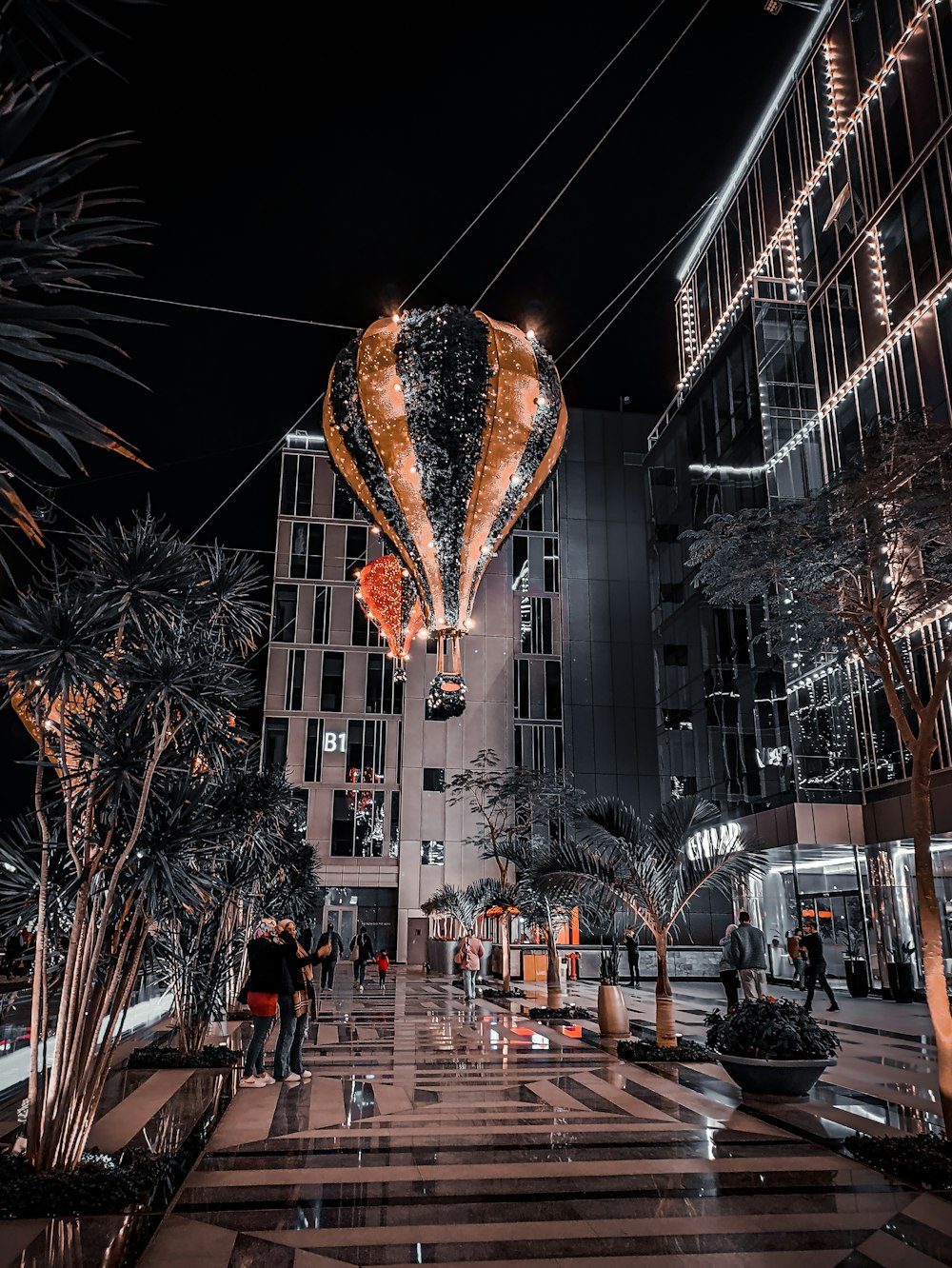 a large hot air balloon flying over a city at night