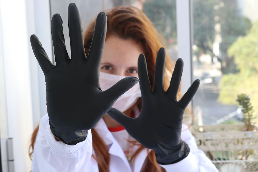 a woman wearing black gloves and a face mask