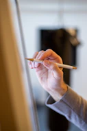 a woman holding a pencil in her right hand