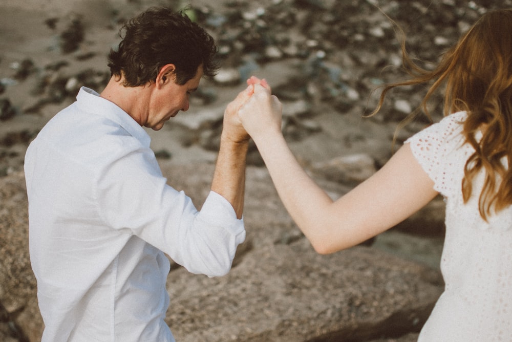 a man and a woman holding hands while standing next to each other