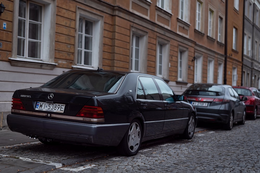 a row of parked cars on a cobblestone street