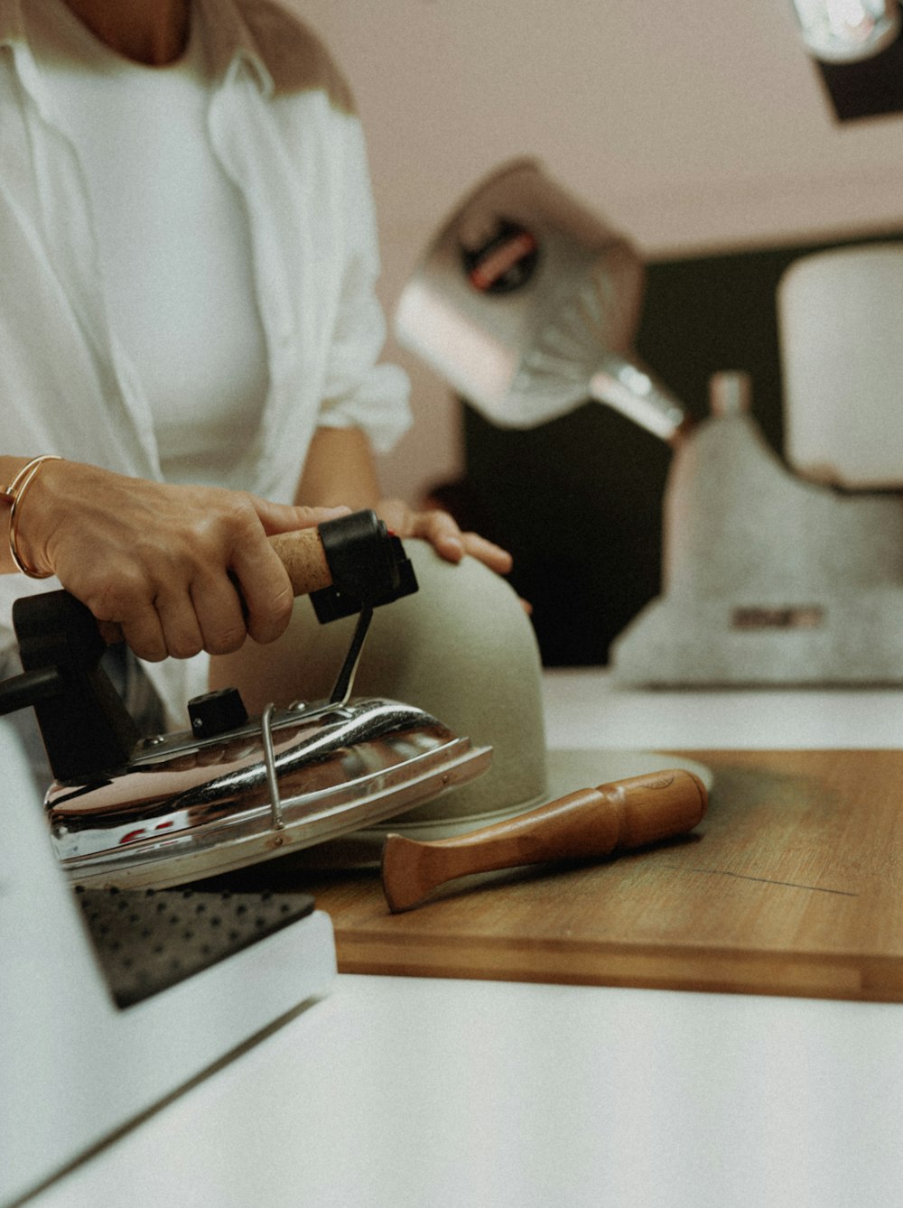 a woman is using a hand grinder on a cutting board