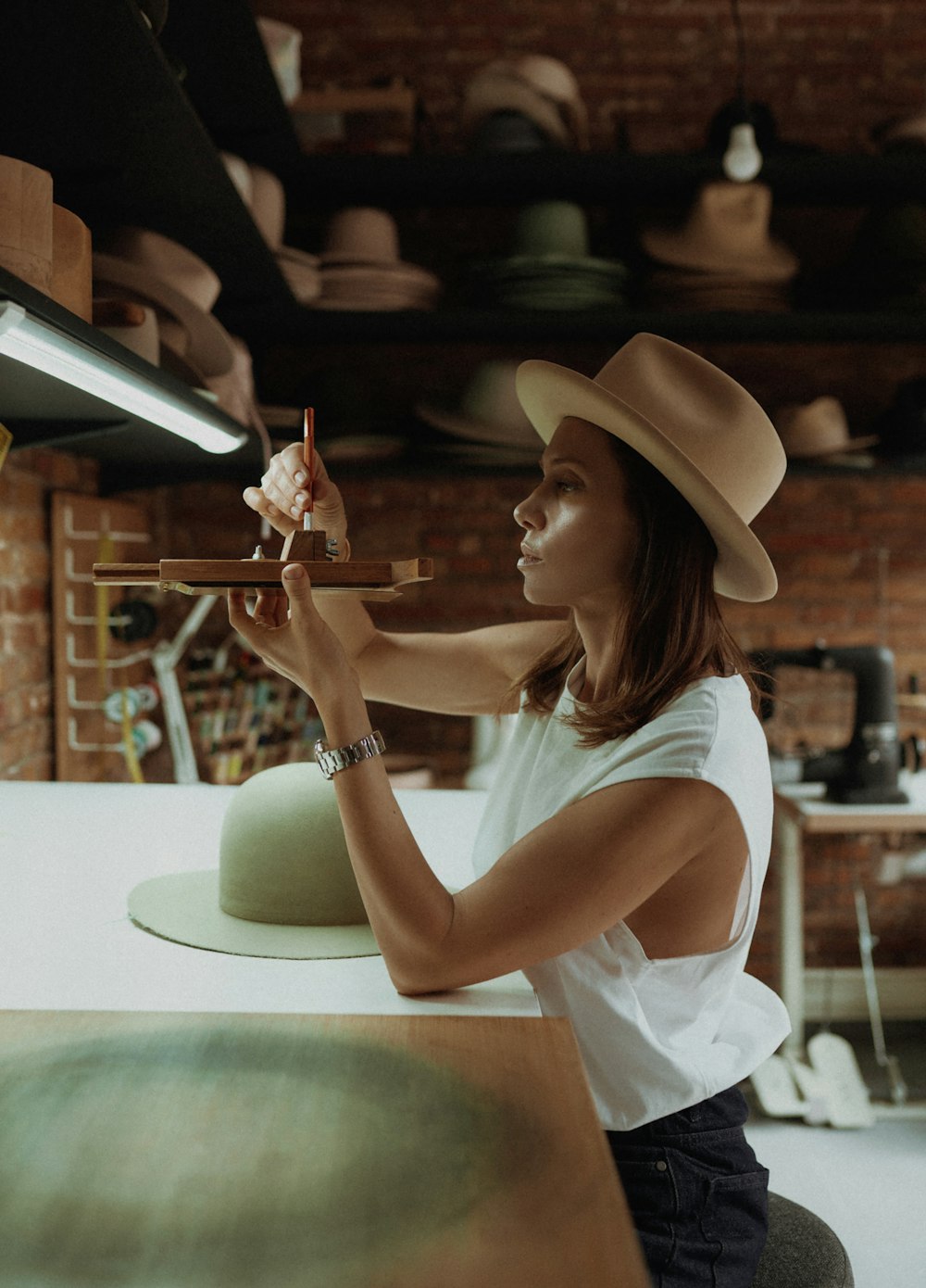 a woman in a hat is holding a toy airplane