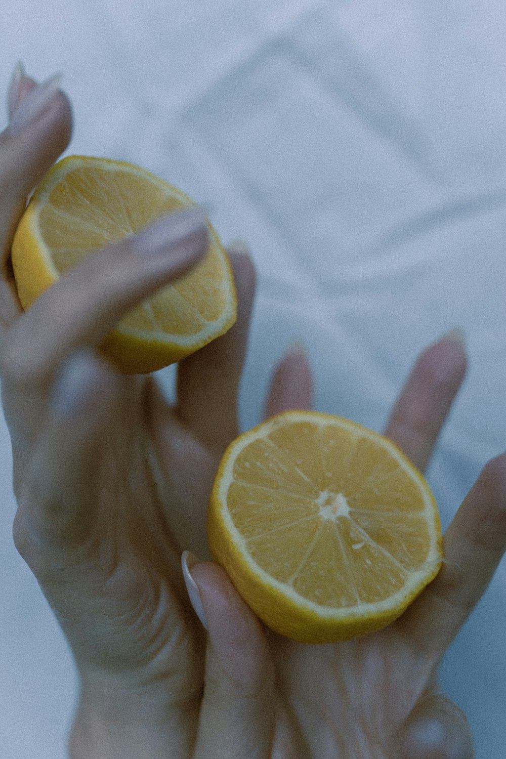 a person holding two halves of a lemon