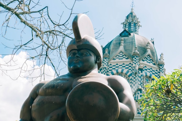a statue of a man holding a ball in front of a building