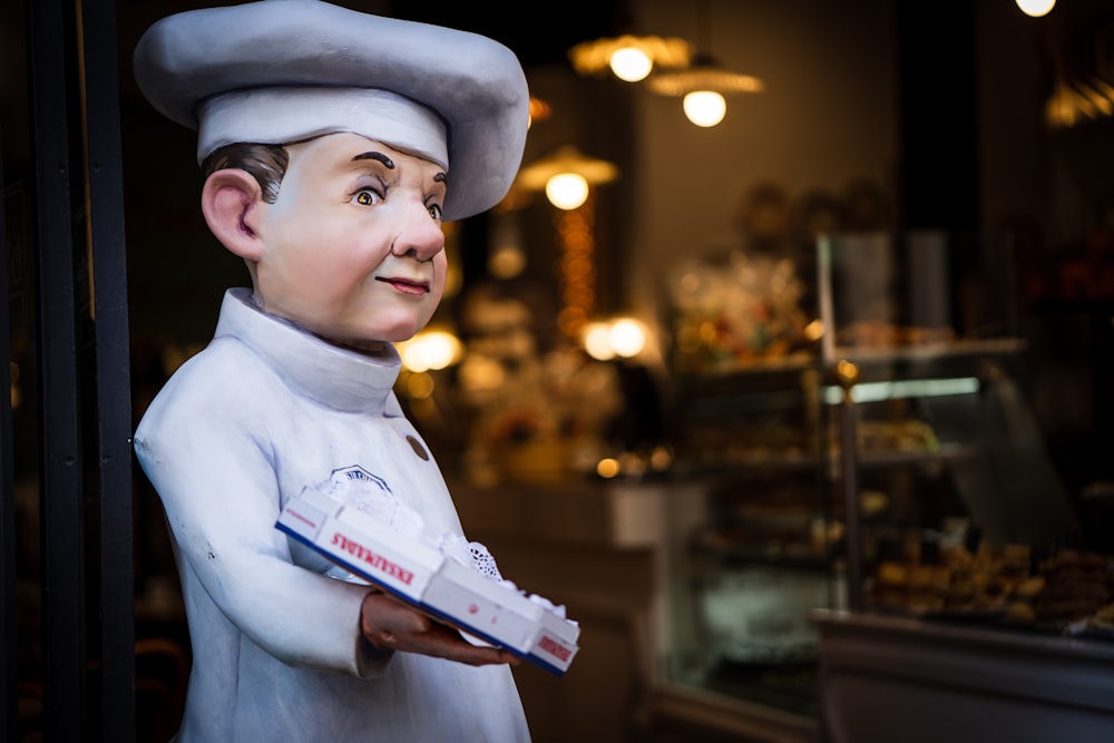 Una estatua de un chef sosteniendo una caja de donuts