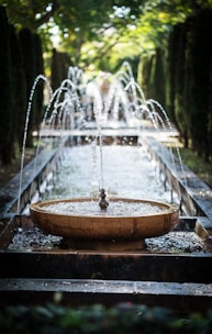 A serene water fountain surrounded by natural stones in a peaceful garden setting