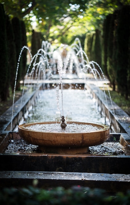 A serene water fountain surrounded by natural stones in a peaceful garden setting