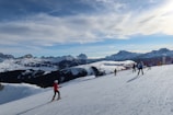A scenic view of snow-covered mountains with skiers in action.