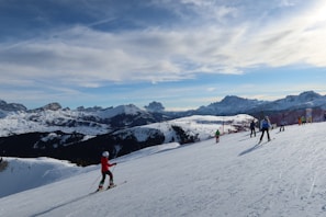 A scenic view of snow-covered mountains with skiers in action.