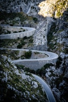 A winding mountain road engineered with safety barriers and smooth curves.