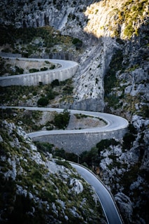 A winding mountain road engineered with safety barriers and smooth curves.