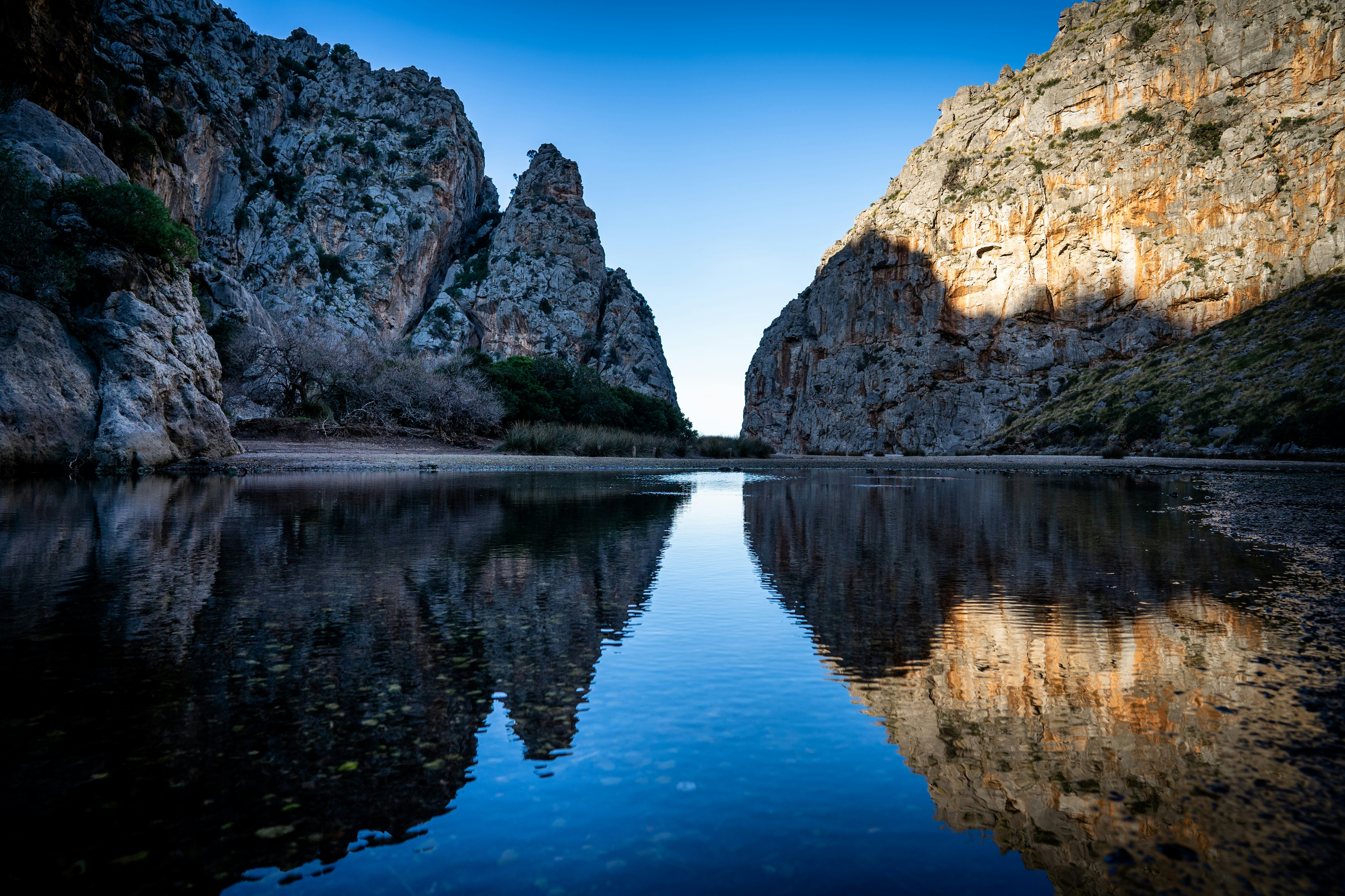 uno specchio d'acqua circondato da montagne e alberi