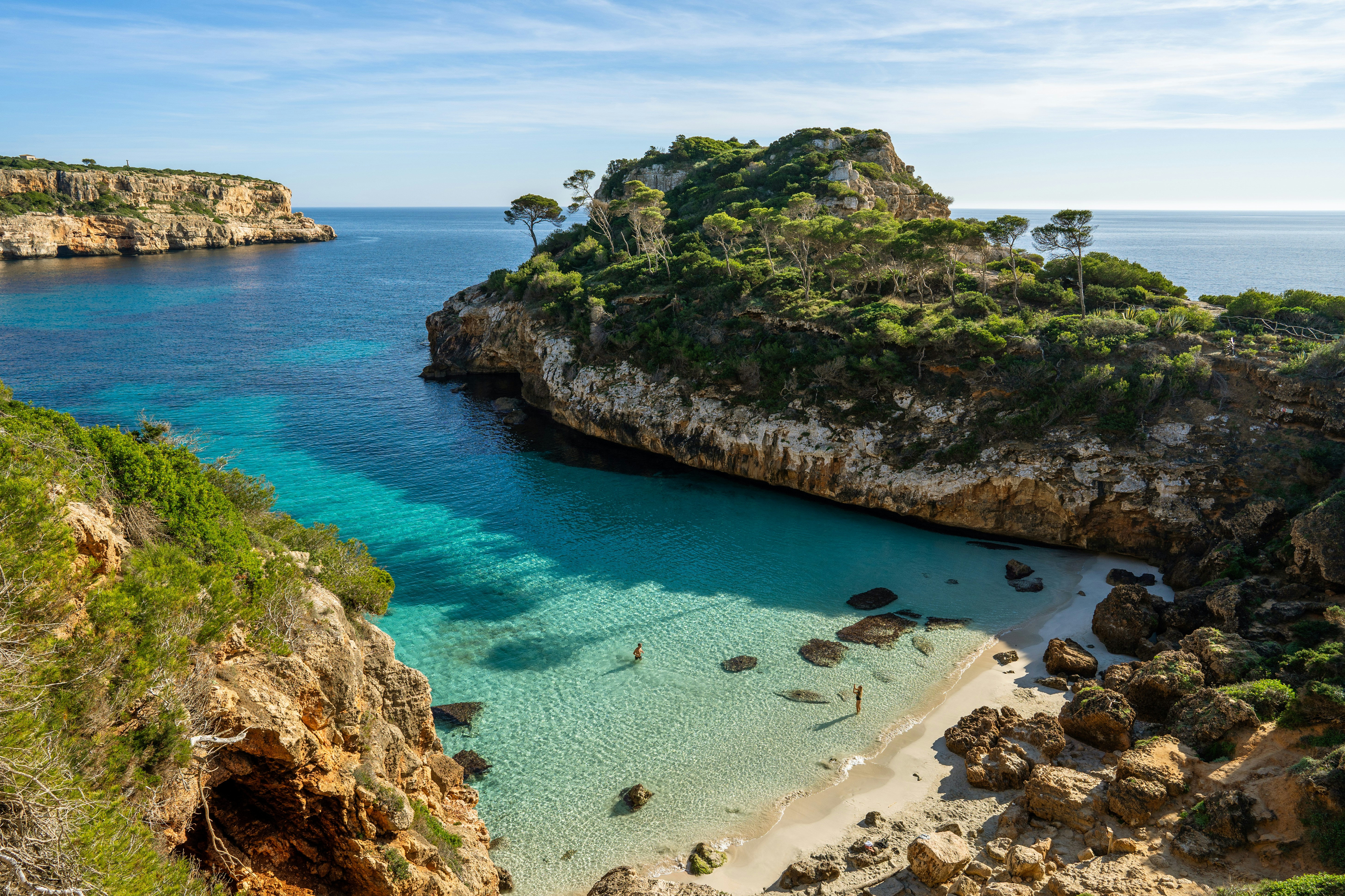 Una spiaggia con acqua cristallina accanto a una scogliera