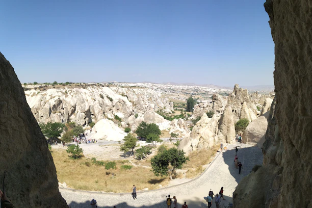 Smiling tourists exploring colorful rock formations under a clear blue sky.