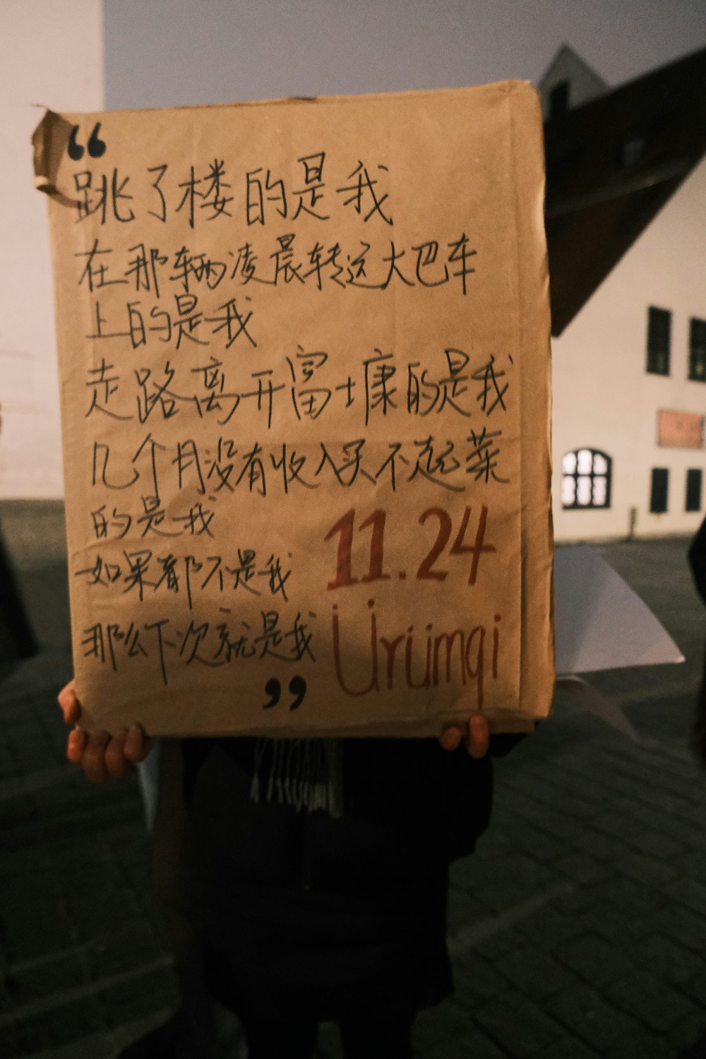 a person holding a sign with writing on it