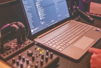 a laptop computer sitting on top of a dj workstation