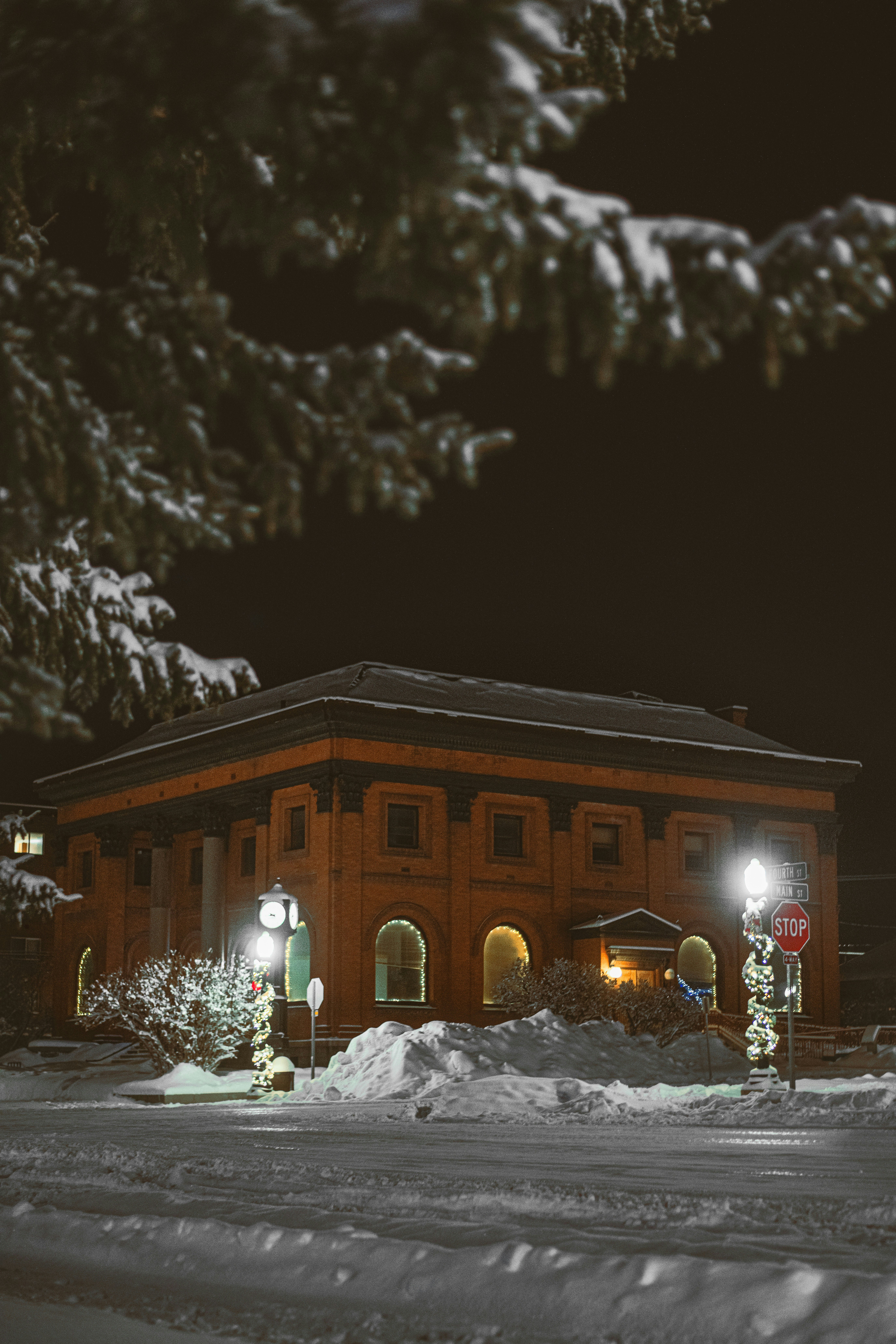 eine schneebedeckte Straße bei Nacht mit einem Gebäude im Hintergrund