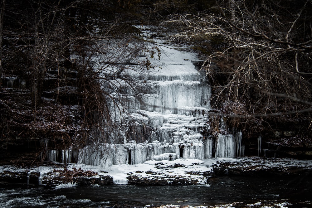 a frozen waterfall surrounded by trees and snow