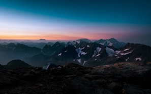 A scenic view of a mountain landscape with a tent in the foreground.