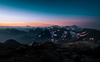 A scenic view of a mountain landscape with a tent in the foreground.