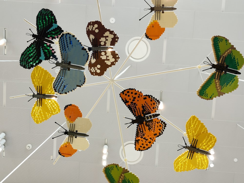 a bunch of colorful butterflies hanging from a ceiling