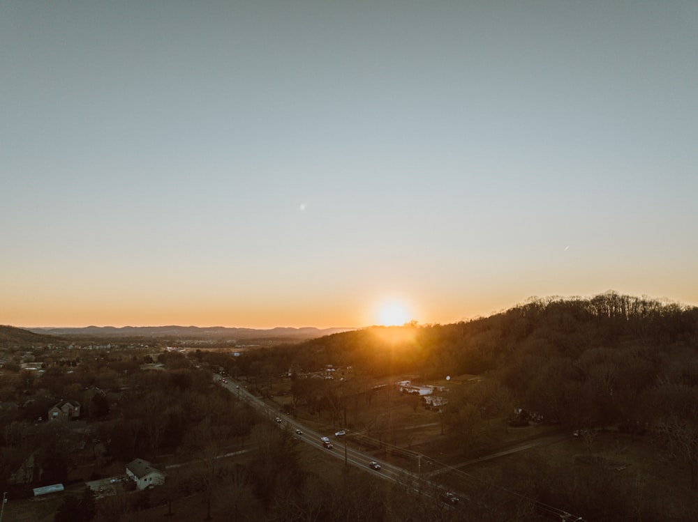 the sun is setting over a small town