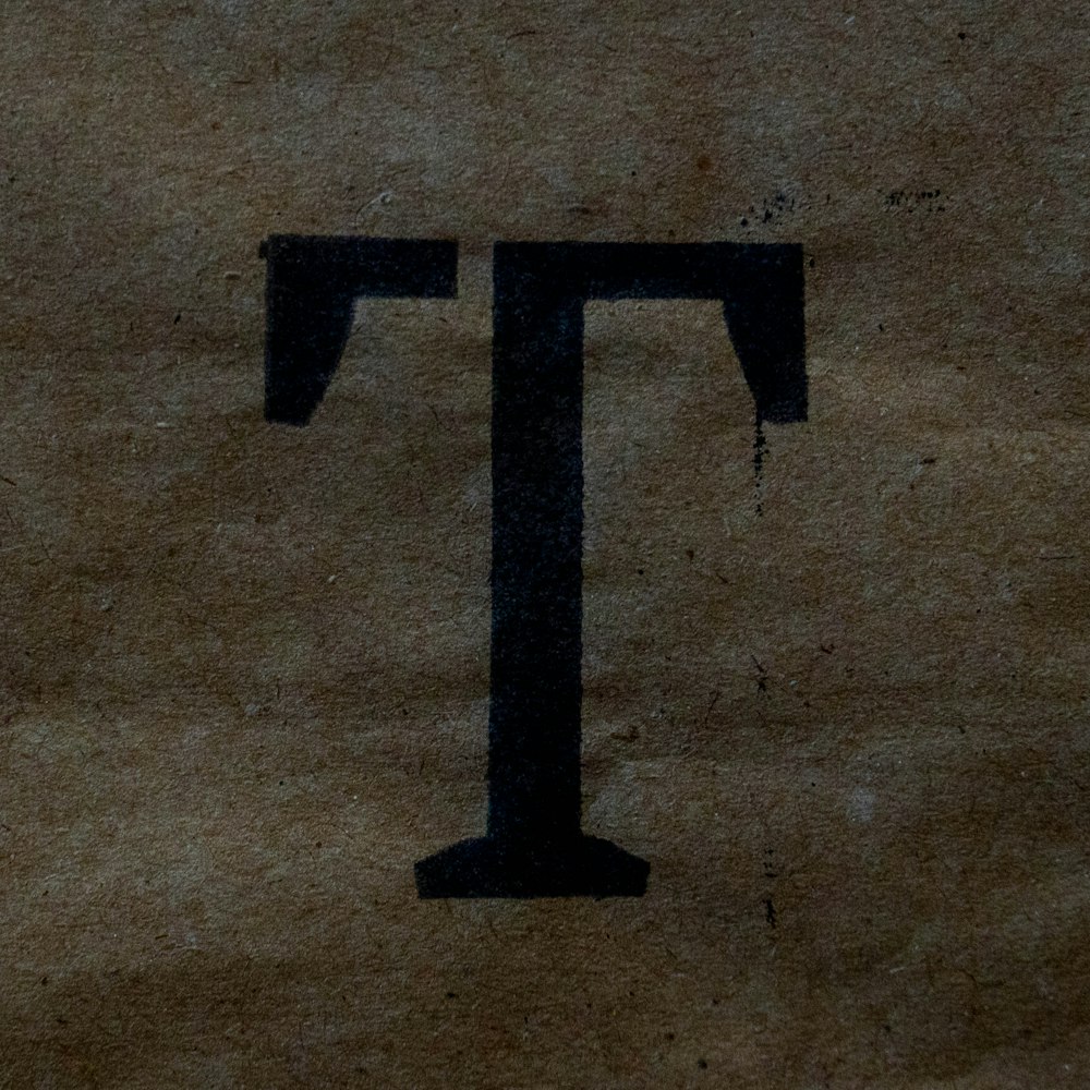 a close up of a piece of paper with the letter t on it
