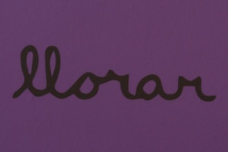 The word 'llorar' is written in a cursive font in black on a purple background.