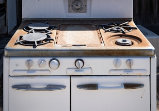 an old white stove with two burners on it