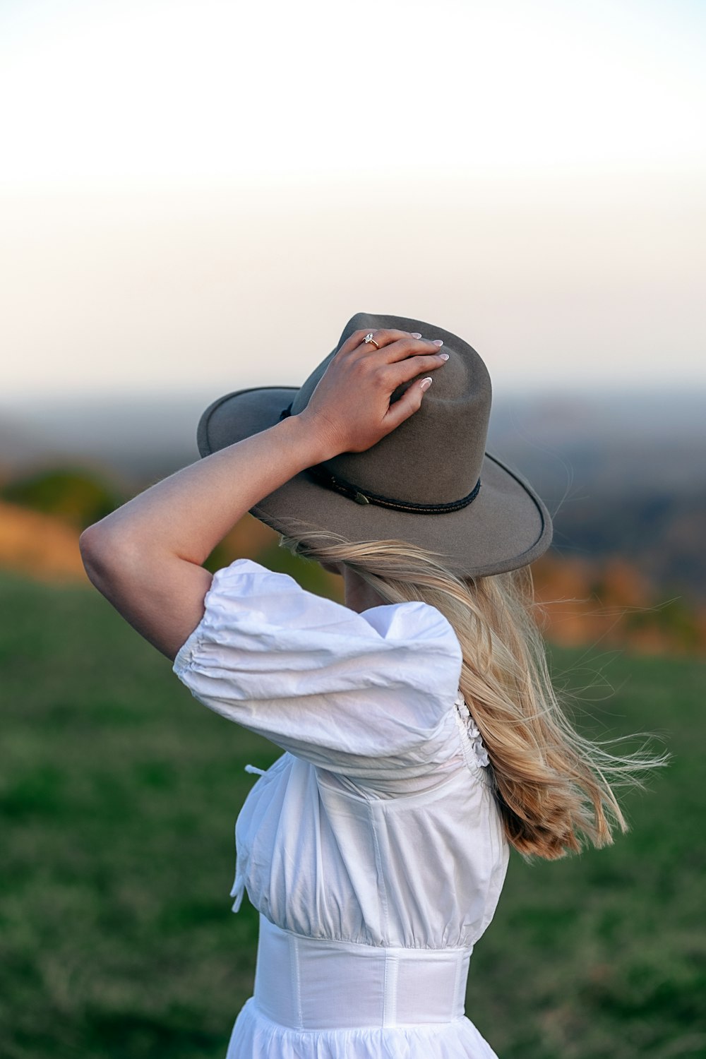 a woman in a white dress and a brown hat